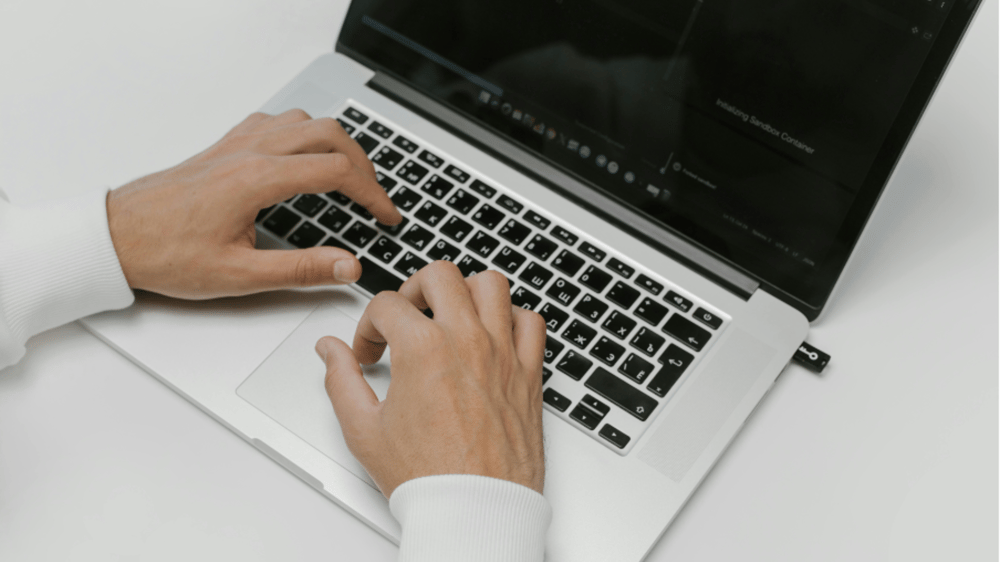 person with hands laying on a laptop