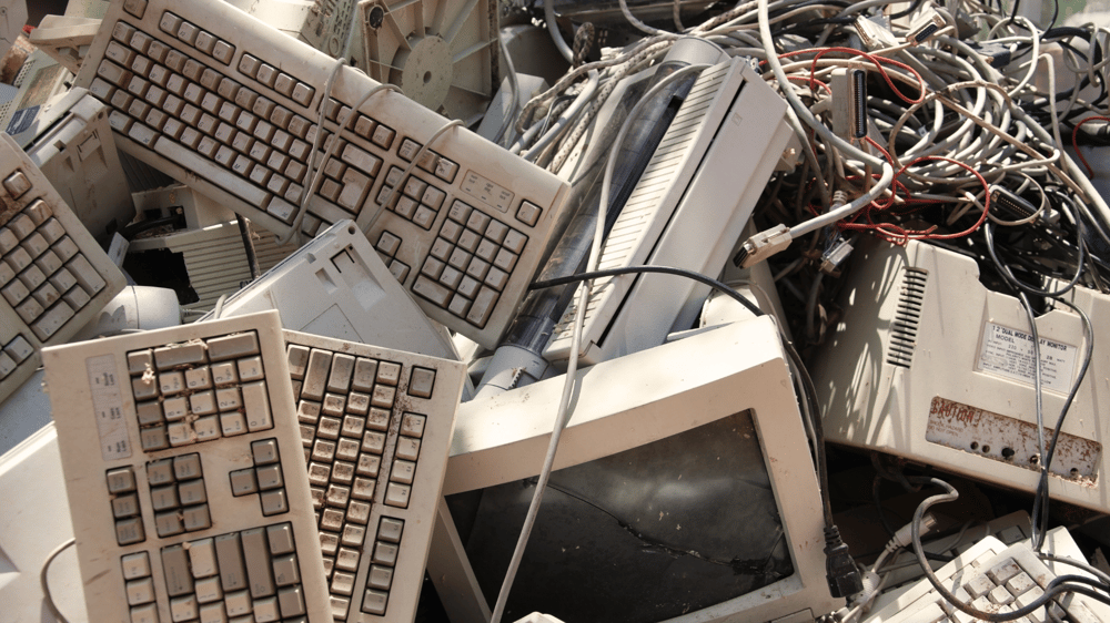 broken computers and keyboards in a pile