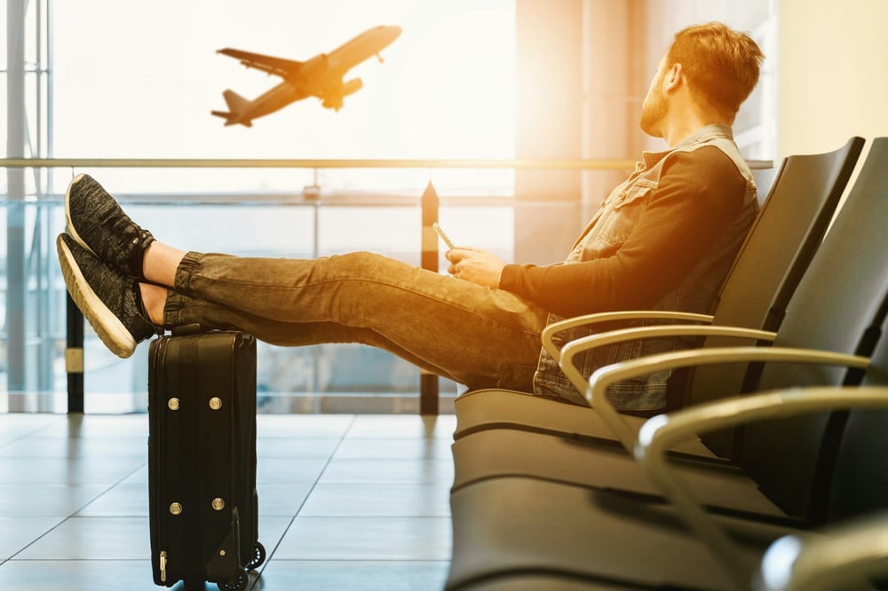 man waiting in airport with luggage