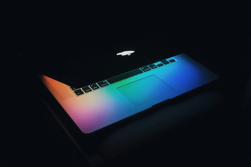 macbook with rainbow lights emerging